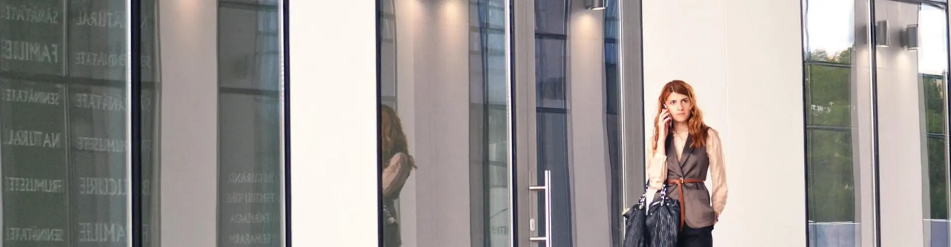 "Frau mit Tasche vor Bürogebäude"