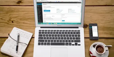 Notizheft, Laptop, Kaffee und Handy