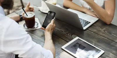 "2 Menschen arbeiten außerhalb des Büros mit Handy und Laptop"