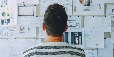 Mann guckt auf Notizwand